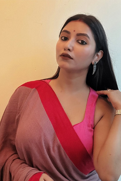 Anjali Housewife in a pink saree posing gracefully indoors, showcasing a traditional yet modern look.