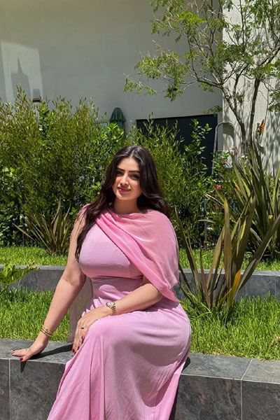 Woman in pink outfit standing by poolside